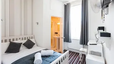 a small white bedroom with a bed and a window at Entire Manor Grove Blackpool in Blackpool