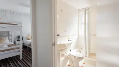 a bathroom with a toilet and a sink and a bed at Entire Manor Grove Blackpool in Blackpool