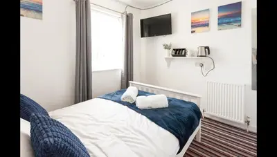 a bedroom with a bed with two towels on it at Entire Manor Grove Blackpool in Blackpool