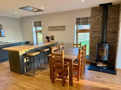 a kitchen with a wooden table and a stove at Ribble Valley Hideaways in Preston