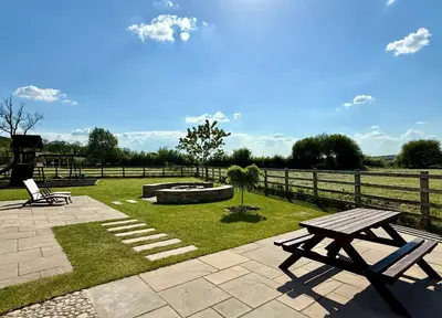 a park with two picnic tables and a fire pit at Ribble Valley Hideaways in Preston