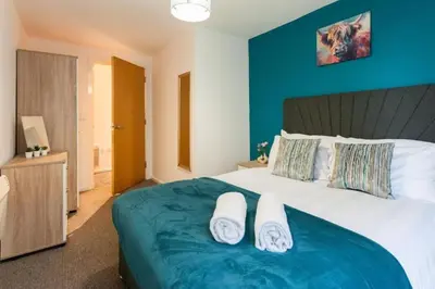 a bedroom with a large bed with blue walls at Elegant City Retreat Contemporary 2BR 2BA Netflix Included in Liverpool