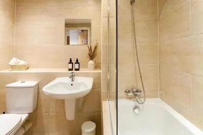 a bathroom with a toilet and a sink and a shower at Elegant City Retreat Contemporary 2BR 2BA Netflix Included in Liverpool