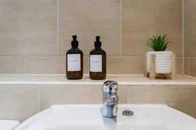 two bottles of wine sitting on a bathroom sink at Elegant City Retreat Contemporary 2BR 2BA Netflix Included in Liverpool