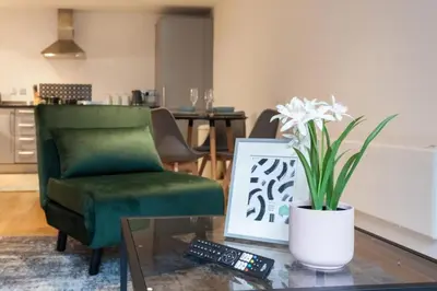 a living room with a green chair and a vase of flowers at Elegant City Retreat Contemporary 2BR 2BA Netflix Included in Liverpool