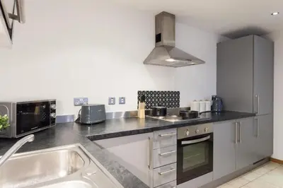 a kitchen with a sink and a microwave at Elegant City Retreat Contemporary 2BR 2BA Netflix Included in Liverpool