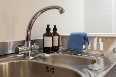 two bottles of wine sitting on a kitchen sink at Prime City Centre Living Large 2 Bed 2 Bath Free Netflix Sleeps 7 in Liverpool