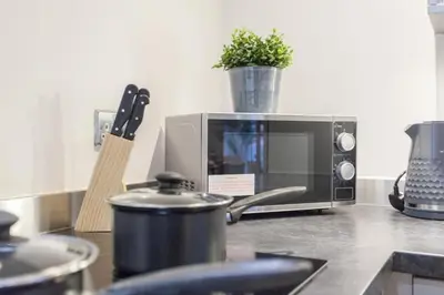 a microwave on a kitchen counter with a pot on top at Prime City Centre Living Large 2 Bed 2 Bath Free Netflix Sleeps 7 in Liverpool