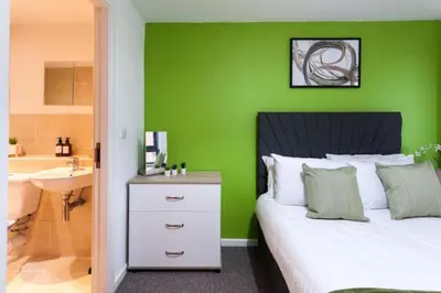 a green bedroom with a bed and a sink at Prime City Centre Living Large 2 Bed 2 Bath Free Netflix Sleeps 7 in Liverpool