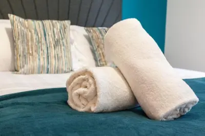 a rolled up towel sitting on top of a bed at Prime City Centre Living Large 2 Bed 2 Bath Free Netflix Sleeps 7 in Liverpool