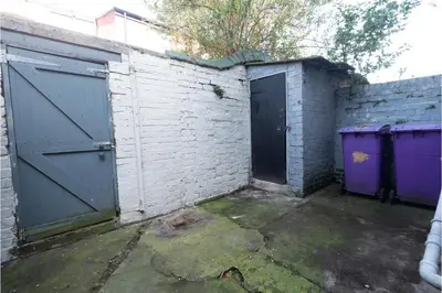 a garage with two doors and a brick wall at Anfield Escape in Liverpool
