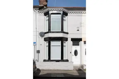 a white house with black windows and a door at Anfield Escape in Liverpool