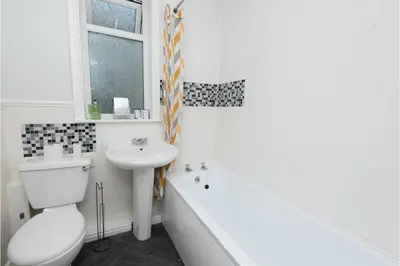 a bathroom with a sink and a toilet and a bath tub at Anfield Escape in Liverpool