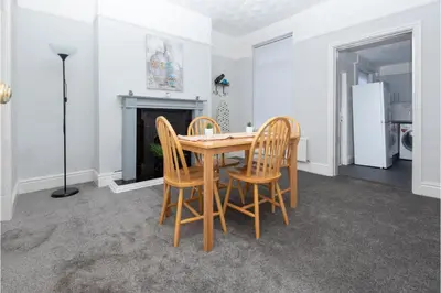 a dining room with a table and chairs and a fireplace at Anfield Escape in Liverpool