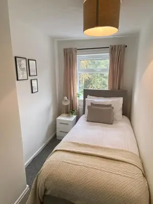 a bedroom with a bed and a window at Comfy and Connected Standish Home - Two Mins from M6 Jct-27 in Standish