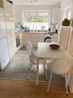 a kitchen with a white table and chairs at Comfy and Connected Standish Home - Two Mins from M6 Jct-27 in Standish