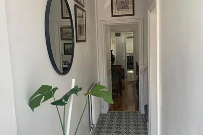 a hallway with a mirror and a plant at Sleeps 7 Home Blackpool w Free Parking BBq WiFi in Blackpool
