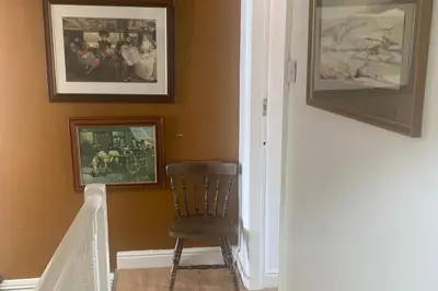 a stairway with a chair and pictures on the wall at Sleeps 7 Home Blackpool w Free Parking BBq WiFi in Blackpool