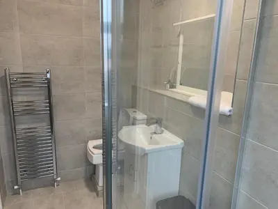a bathroom with a toilet and a sink and a shower at Sleeps 7 Home Blackpool w Free Parking BBq WiFi in Blackpool