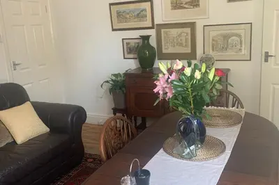 a living room with a table with a vase of flowers at Sleeps 7 Home Blackpool w Free Parking BBq WiFi in Blackpool