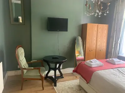 a bedroom with a bed and a table and chairs at Sleeps 7 Home Blackpool w Free Parking BBq WiFi in Blackpool