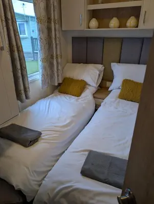 a group of beds in a room with a window at Wilerby Winchester in Heysham