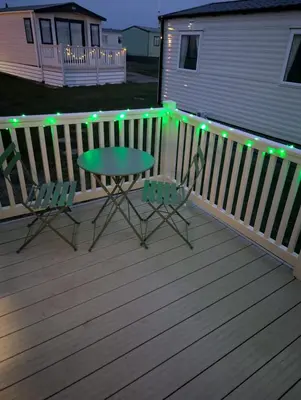 a patio with a table and chairs on a deck at Wilerby Winchester in Heysham