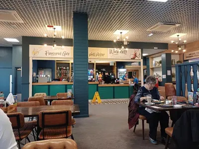 a woman sitting at a table in a restaurant at Wilerby Winchester in Heysham