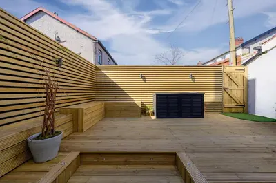 a patio with a wooden wall and a potted plant at Luxury Modern Home Great Harwood - Sleeps Up to 8 in Great Harwood
