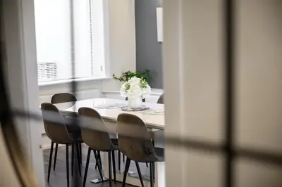 a dining room table with chairs and a vase of flowers at Luxury Modern Home Great Harwood - Sleeps Up to 8 in Great Harwood