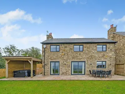 a stone house with a patio and a grill at Meadow View - Uk49066 in Mellor