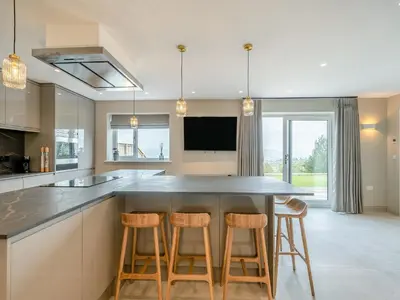 a kitchen with a large island with bar stools at Meadow View - Uk49066 in Mellor