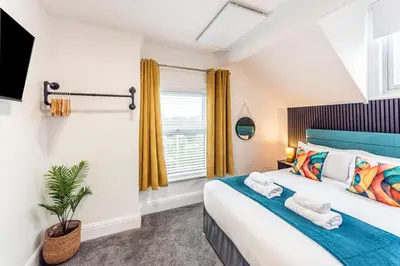 a bedroom with a large bed and a window at The Sage in Lytham St Annes