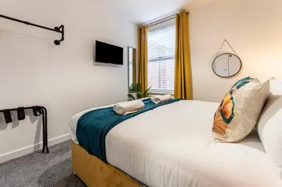 a bedroom with a bed with towels on it at The Sage in Lytham St Annes