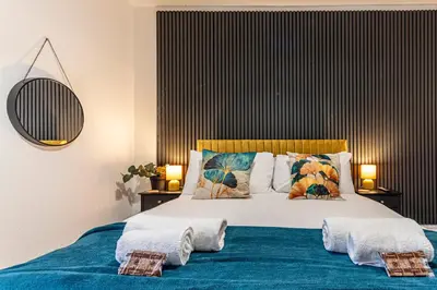a bedroom with a large bed with towels on it at The Sage in Lytham St Annes