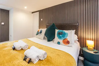 a bedroom with a large bed with towels on it at The Sage in Lytham St Annes