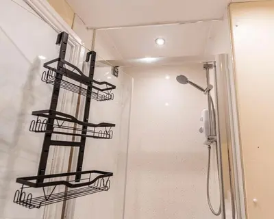 a shower with black shelves in a bathroom at The Sage in Lytham St Annes