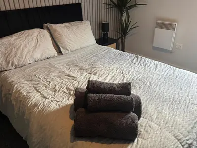 a bed with a pile of towels on it at 2 Bedroom Apartment - Henry St Central Liverpool in Liverpool