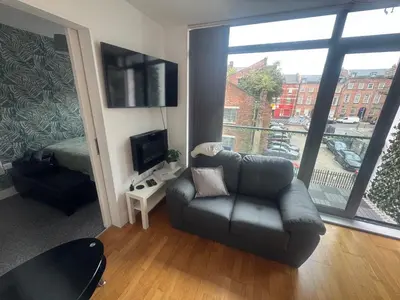 a living room with a couch and a large window at 2 Bedroom Apartment - Henry St Central Liverpool in Liverpool