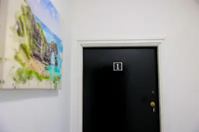 a black door with a picture on the wall at Edinburgh Road Guest House in Liverpool