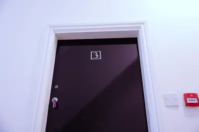 a black door with a pink ribbon on it at Edinburgh Road Guest House in Liverpool