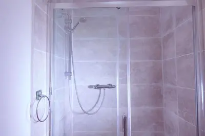 a shower with a glass door in a bathroom at Edinburgh Road Guest House in Liverpool