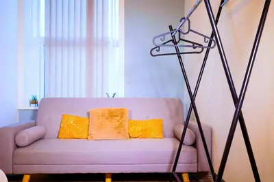 a living room with a purple couch with two orange pillows at Edinburgh Road Guest House in Liverpool