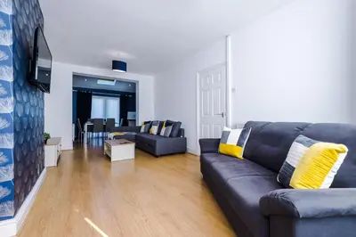 a living room with a couch and a table at Charming Home in Merseyside, sleeps 7 in Liverpool