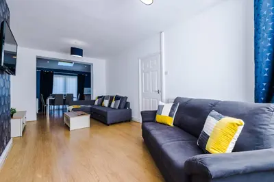 a living room with a couch and a table at Charming Home in Merseyside, sleeps 7 in Liverpool