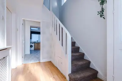 a staircase in a home with white walls and wooden floors at Charming Home in Merseyside, sleeps 7 in Liverpool