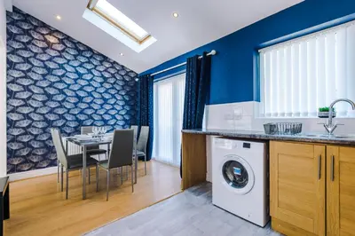 a kitchen and dining room with a table and chairs at Charming Home in Merseyside, sleeps 7 in Liverpool