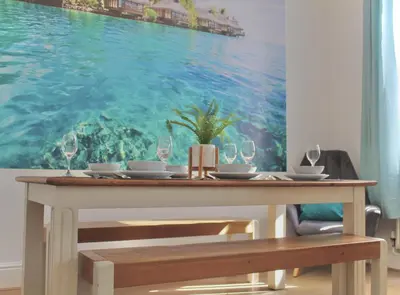 a dining room table with a painting of the ocean at Your lovely 3-bed home-from-home in Bamber Bridge in Bamber Bridge