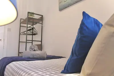 a bedroom with a bed with blue pillows and a basketball hoop at Your lovely 3-bed home-from-home in Bamber Bridge in Bamber Bridge