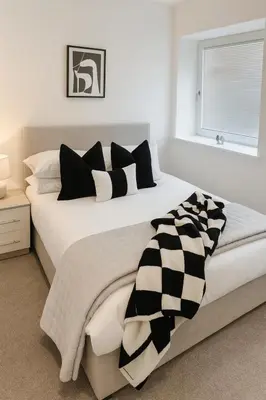 a bedroom with a large bed with black and white pillows at Copper Suite - 2Bed Elegance - Parking in Liverpool